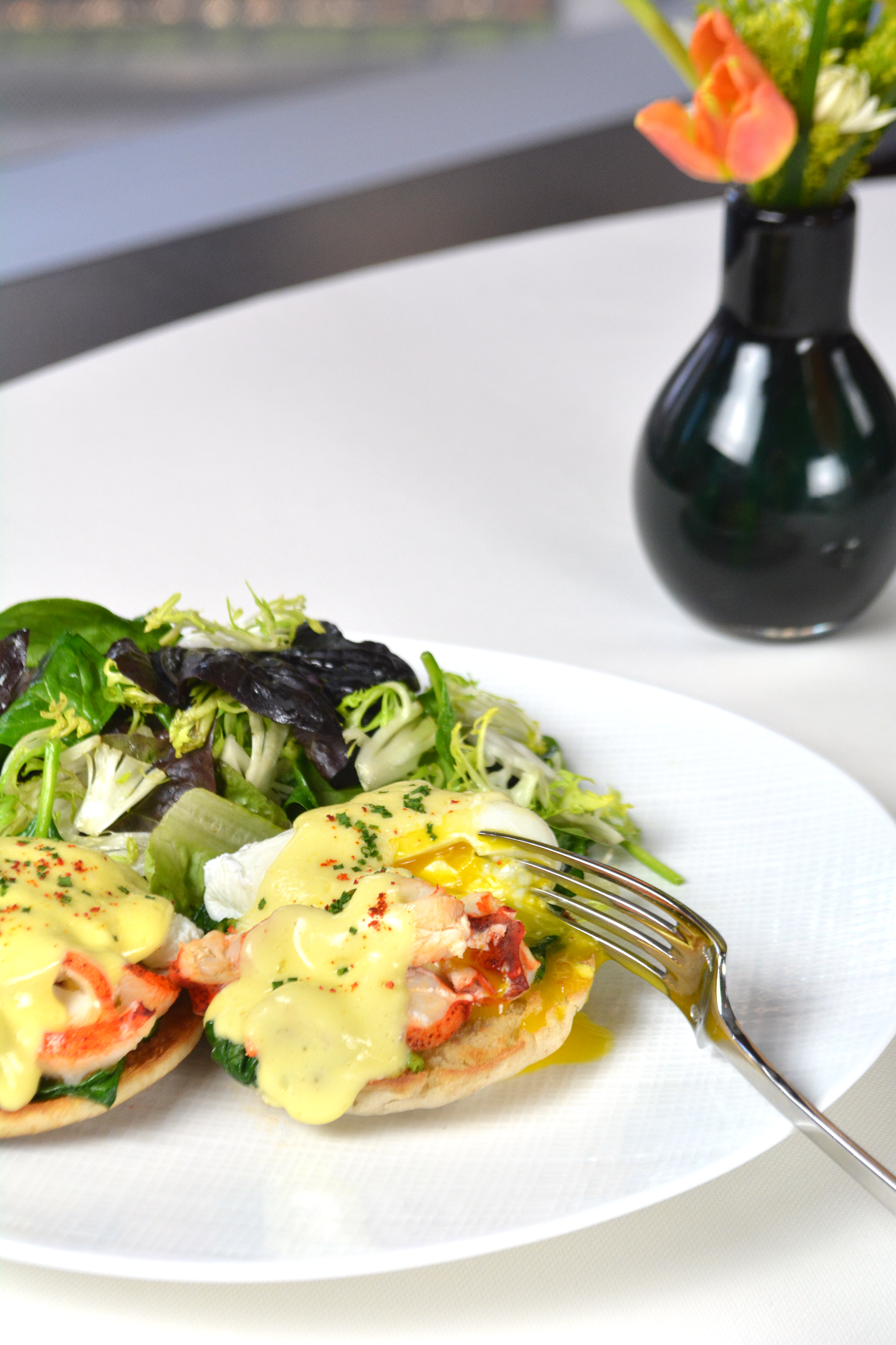 plate of eggs Benedict with a side salad