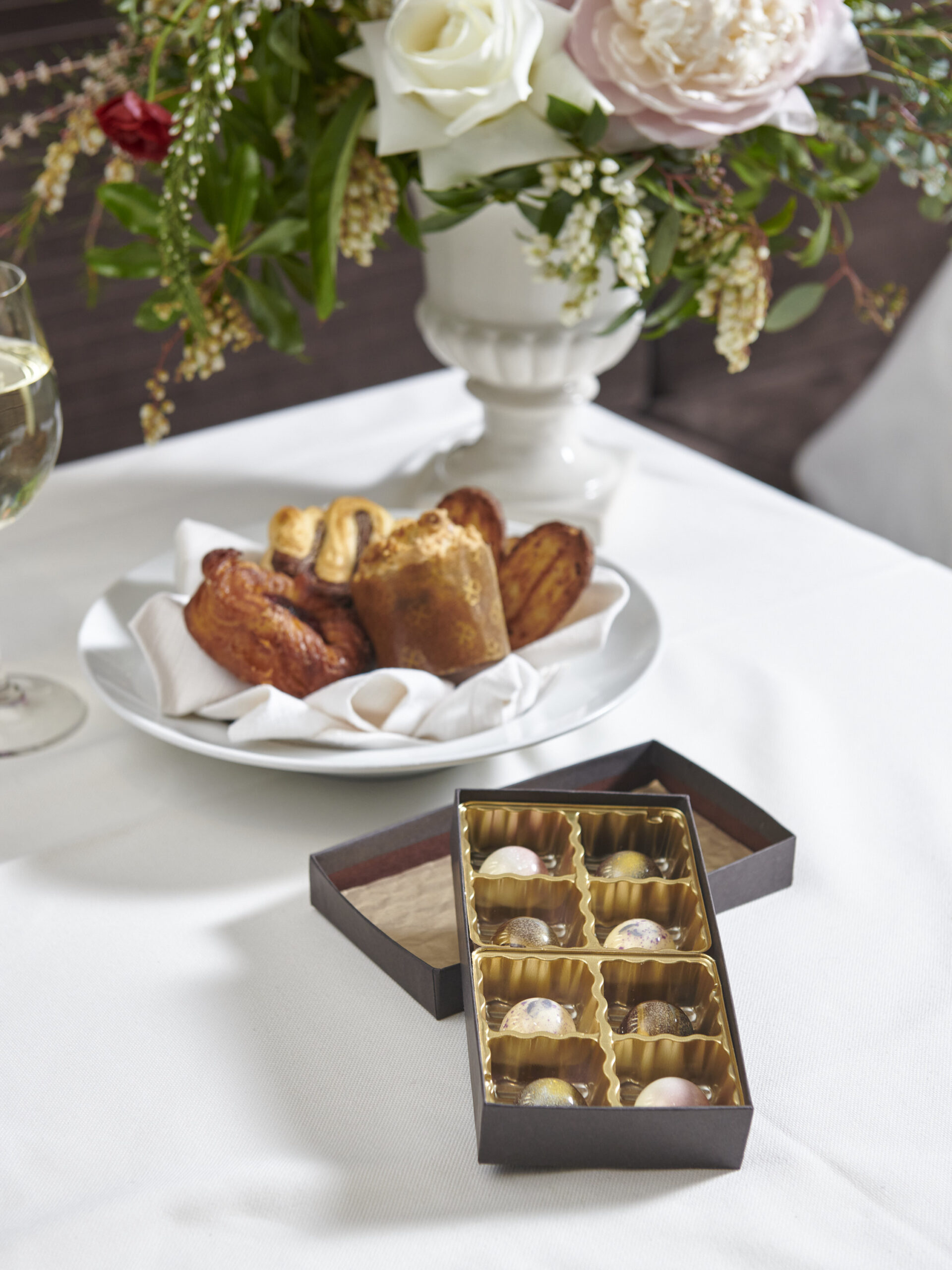 a basket of pastry and a box of bonbons on a table