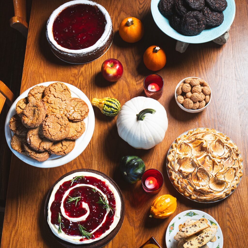 pies, cakes, and cookies in a spread with a variety of pumpkin, squash, and apple decorations