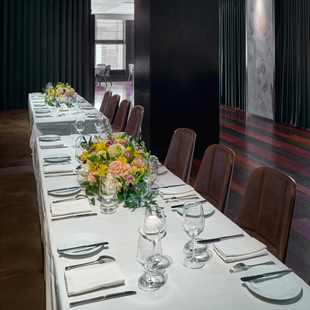 savona private dining table at ai fiori - a long rectangular table with a banquet on one side and brown leather chairs on the other