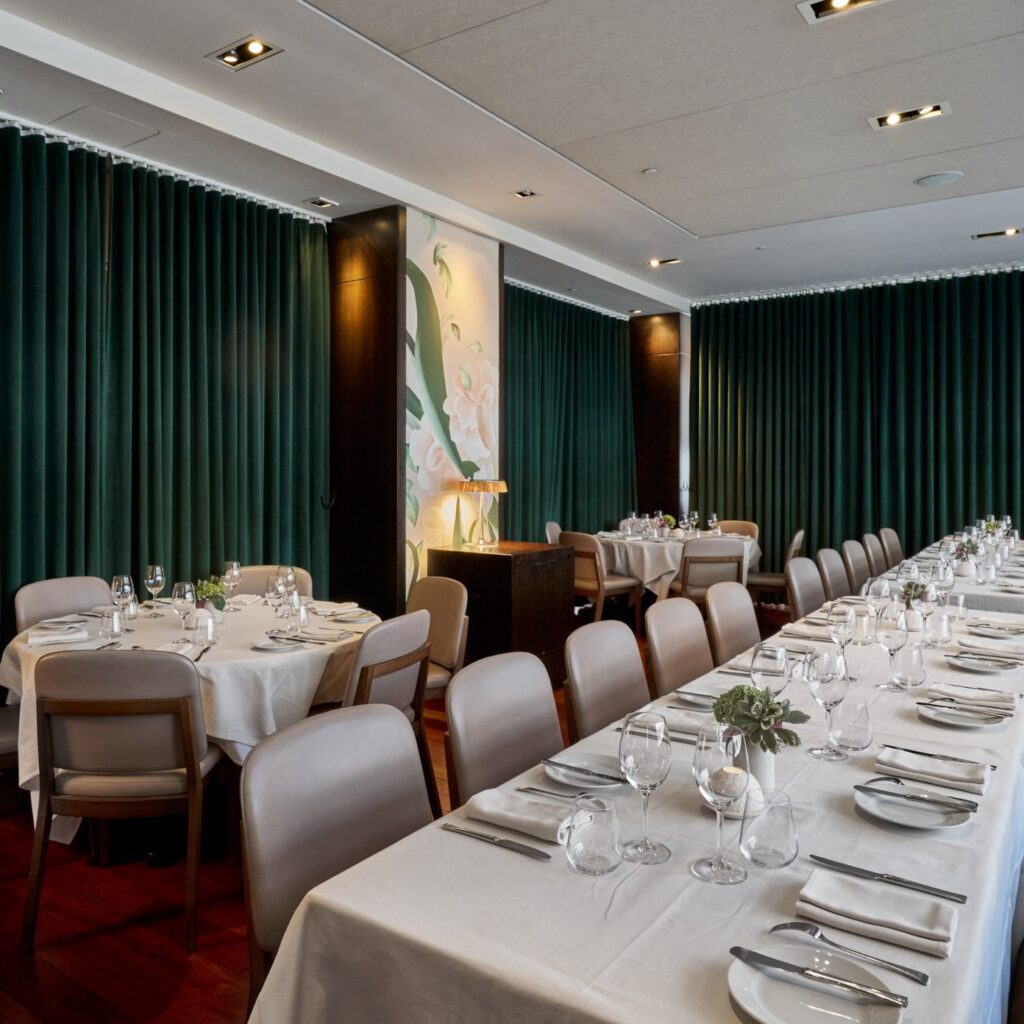 Genoa Private Dining Room at Ai Fiori - a long rectangular table runs along a banquet with two round tables parallel