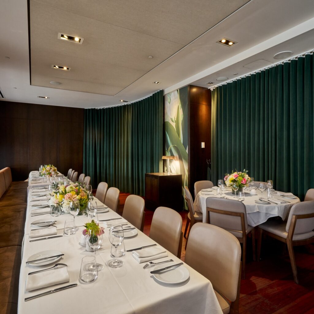 la spezia semi-private dining room at ai fiori - a long table lines a banquet to the left with a large round table to the right