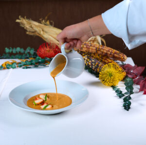 Woman in striped dress and large straw hat in a dry field at Menorca Experimental.